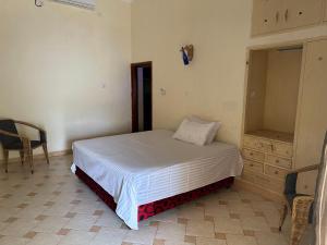 a bedroom with a bed and a dresser in it at Heidi’s Beach Stay in Mombasa