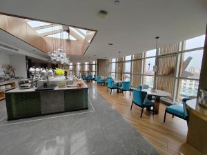 - un hall avec des chaises, des tables et des fenêtres bleues dans l'établissement Tuke China Hotel Shanghai Hongqiao Airport, à Shanghai