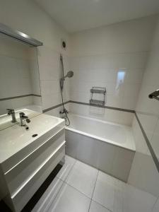 a white bathroom with a sink and a tub at Apartment Maluchy in Hrabŭvka