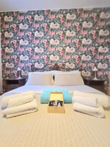 um quarto com uma cama com uma parede floral em Villa Sofia em Sirtori