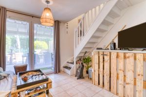 a living room with a tv and a staircase at Maison - Residence avec piscine in Calvisson