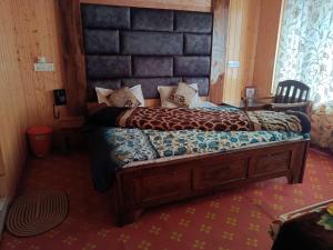 a bedroom with a large bed with a large headboard at Hotel Gulfam Palace in Pahalgām