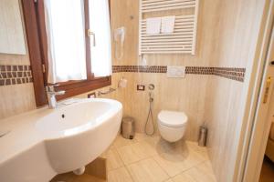 a bathroom with a white sink and a toilet at Duomo Boutique Hotel in Chioggia