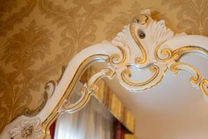 a stairway with a white and gold painted wall at Duomo Boutique Hotel in Chioggia