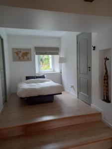 a bedroom with a bed sitting on a wooden floor at Le temps retrouvé in Rouvres-la-Chétive