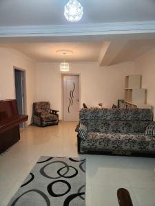 - une chambre avec un lit, une chaise et un tapis dans l'établissement 53 jincharadze street, à Batoumi