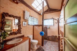 a bathroom with a toilet and a sink and a mirror at ธารทอง ลอดจ์ Tharnthong Lodge in Ban Pang Champi