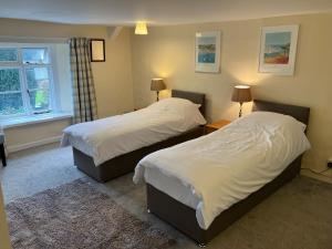 a bedroom with two beds and a window at The Annex at Middle Filham in Ivybridge