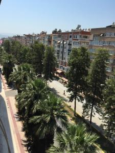 a city street with palm trees and buildings at Hotel Ünlü in Aydın