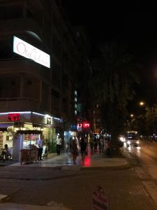 a group of people walking down a street at night at Hotel Ünlü in Aydın