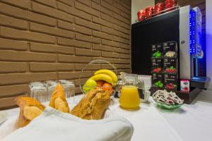 uma mesa com uma cesta de pão e sumo de laranja em ParkCity rooms em Sibenik