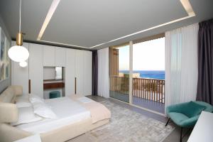 Un dormitorio con una cama y un balcón. en Luxurious 5 Bedroom Beach Villa, en Palasë