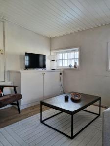 a living room with a coffee table and a tv at Hurmaava ullakkoasunto Vanhan Rauman laidalla in Rauma