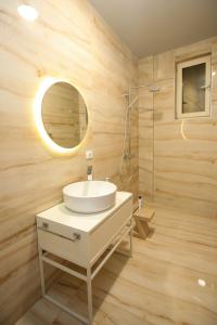 Un baño con un lavabo blanco y un espejo. en Luxurious 5 Bedroom Beach Villa, en Palasë