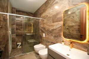 Un baño con inodoro, ducha y lavabo. en Luxurious 5 Bedroom Beach Villa, en Palasë 44 fotos más