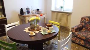una mesa con tazas y flores en una habitación en Casa Cairo Rooms&Services, en Mombaroccio