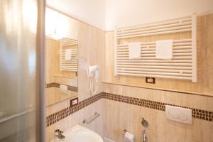 a bathroom with a sink and a toilet and a mirror at Duomo Boutique Hotel in Chioggia +37 photos