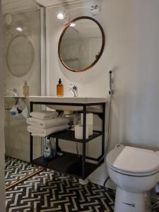 a bathroom with a sink and a toilet and a mirror at Hurmaava ullakkoasunto Vanhan Rauman laidalla in Rauma