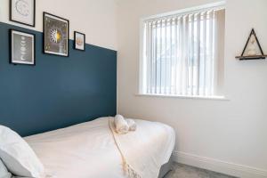 彼得伯勒的住宿－Idyllic 3-bed home with Parking in Peterborough by HP Accommodation，卧室配有白色的床和窗户。