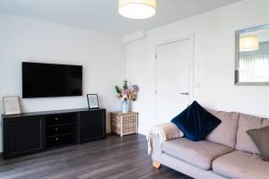 a living room with a couch and a flat screen tv at Idyllic 3-bed home with Parking in Peterborough by HP Accommodation in Peterborough
