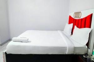 a bedroom with a white bed with red accents at Hotel Inn sky in New Delhi