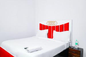 a white bed with a red and white headboard at Hotel Inn sky in New Delhi