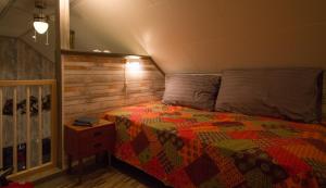 a bedroom with a bed with a colorful quilt at Nice little house right by the sea, stunning view! in Renså
