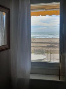 a room with a window with a view of the beach at Beach front room NOT A HOTEL in Castelldefels