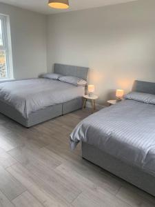 1 dormitorio con 2 camas y 2 mesas con lámparas en Kilmoon Cottage, Entire home in Lisdoonvarna en Lisdoonvarna