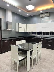 a kitchen with a dining table and white chairs at Diliduth Home in Cao Bằng