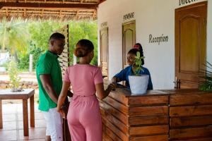 a woman in a pink dress standing in front of a counter at Long Beach Resort, Nosy Be in Nosy Be
