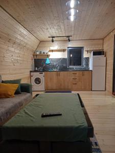 Panorama cottages in Sno في Sno: غرفة معيشة صغيرة مع أريكة وتلفزيون