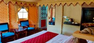 a bedroom with a bed and a table and chairs at Royal Deluxe Camp & Resort, Hunder- Nubra in Nubra