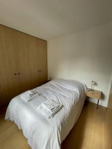 a white bed in a room with a night stand at Hipster Paris North in Paris