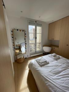 um quarto com uma cama e uma grande janela em Hipster Paris North em Paris