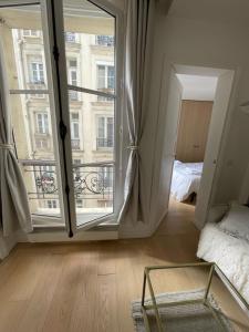 a room with a large window and a bed and a bedroom at Hipster Paris North in Paris