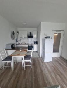 a kitchen with a table and chairs and a refrigerator at Sweet-Home in Hannover