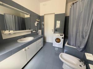 a bathroom with a sink and a washing machine at Villa Paola by the sea in Cozze