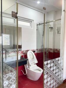 a bathroom with a toilet and a glass shower at Diliduth Home in Cao Bằng