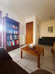 a living room with a coffee table and a book shelf with books at Εξοχικό κατάλυμα στο Βιρο Κέρκυρας in Kastanéa