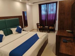 a bedroom with a bed and a chair and a window at Hotel D Tark Near IGI Airport in New Delhi
