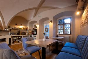 a living room with a wooden table and blue chairs at Hotel Casa Wagner in Sighişoara