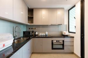 a kitchen with white cabinets and a sink at Exclusive D1mension in District 1 3BR Apartment FreePoolSaunaGym in Ho Chi Minh City