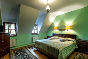 a green bedroom with a bed and two windows at Hotel Casa Wagner in Sighişoara