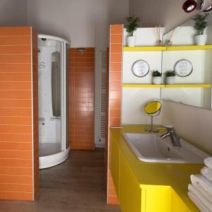 an orange bathroom with a sink and a shower at FilandaLago apartment in Iseo +19 photos