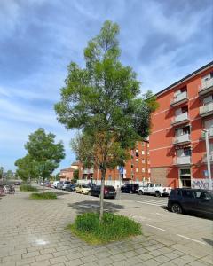 un albero in un parcheggio accanto a un edificio di La Dimora degli Artisti - Bologna a Bologna