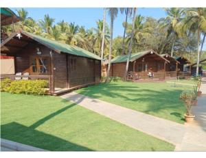 a house with a green yard with two buildings at Anantra Sea View Resort, Agonda, Goa in Agonda