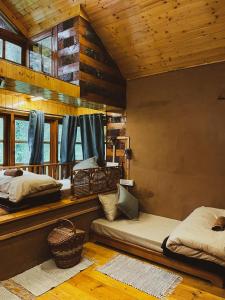 1 dormitorio con 2 camas en una cabaña de madera en The Lazy and Slow en Nagar