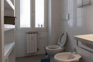 a bathroom with a toilet and a sink and a window at Gibilmanna Home in Rome