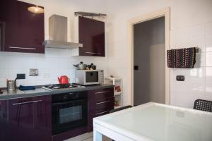 a kitchen with purple cabinets and a stove top oven at Gibilmanna Home in Rome